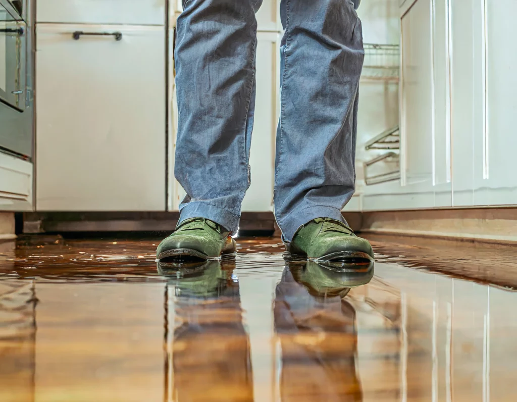 Cuisine innondée avec une personne se tenant debout avec des bottes